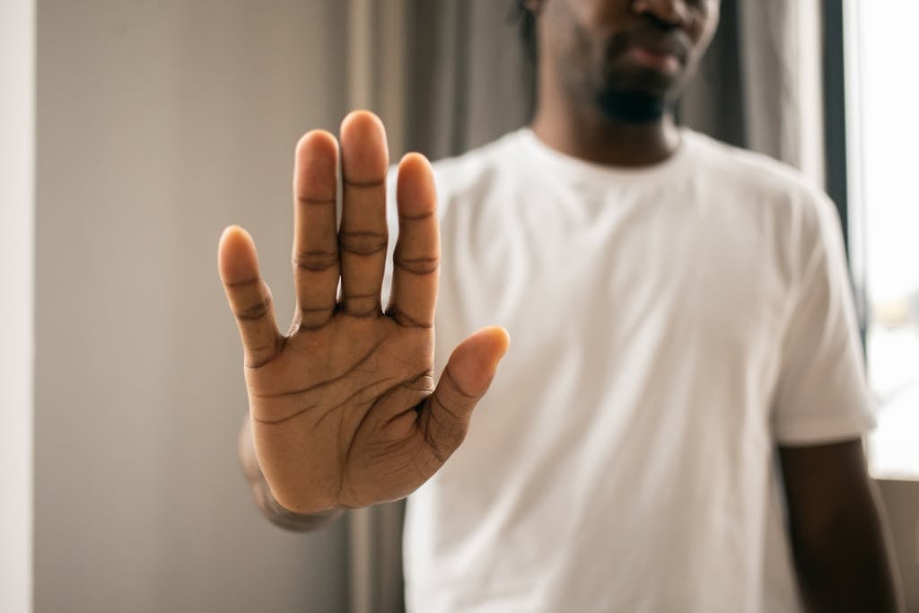 Unrecognizable black man showing stop gesture